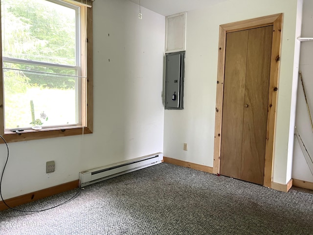 empty room with electric panel, carpet floors, and a baseboard heating unit