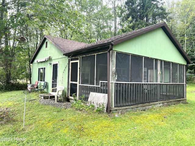 view of property exterior featuring a lawn and a sunroom