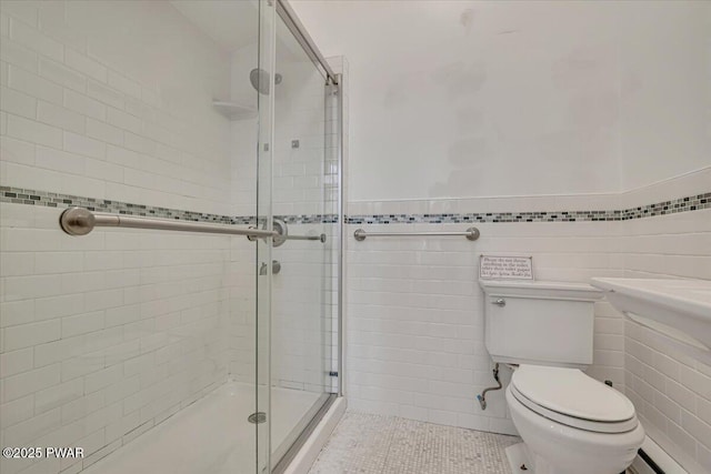 full bathroom with toilet, tile walls, a shower stall, and tile patterned flooring