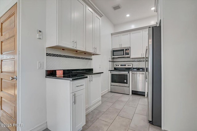 kitchen featuring visible vents, backsplash, dark countertops, stainless steel appliances, and white cabinets