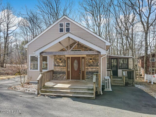 view of front of home with stone siding and covered porch