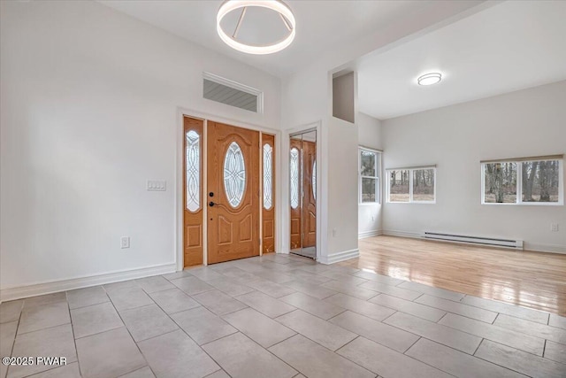 foyer featuring wood finished floors, baseboards, and a baseboard radiator