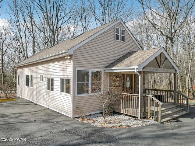 view of front of home with stone siding and a shingled roof