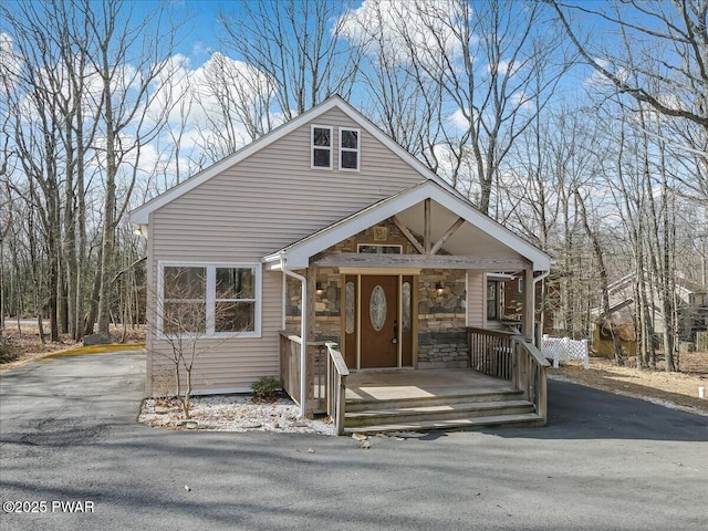 chalet / cabin with stone siding and covered porch