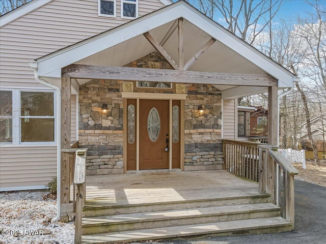 property entrance featuring stone siding and a porch