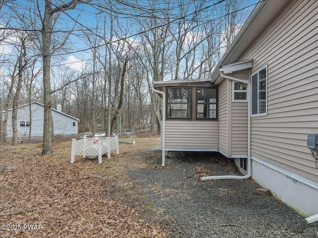 view of yard featuring driveway and a sunroom