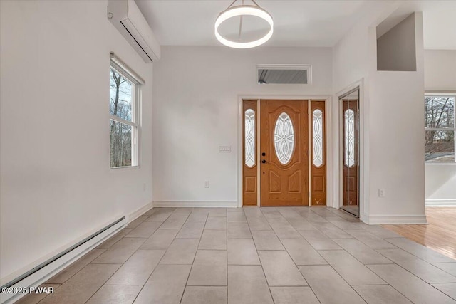 entrance foyer featuring a baseboard heating unit, baseboards, an AC wall unit, and light tile patterned flooring