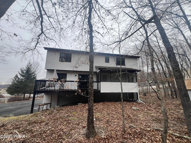 rear view of house featuring a wooden deck