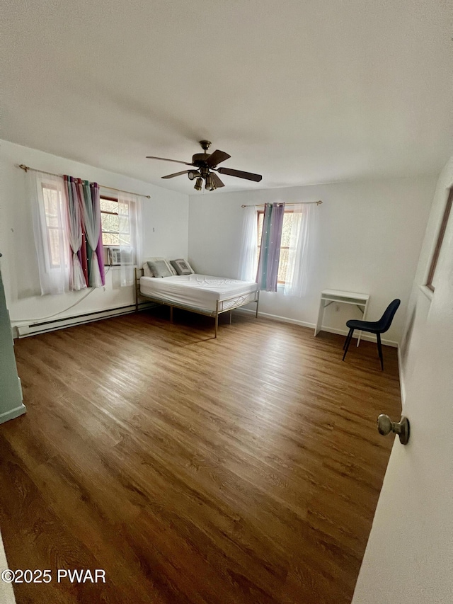 unfurnished bedroom with ceiling fan, baseboard heating, cooling unit, and dark hardwood / wood-style flooring