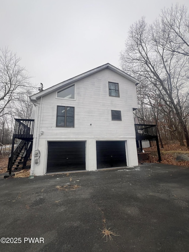 view of side of property with a garage and a wooden deck