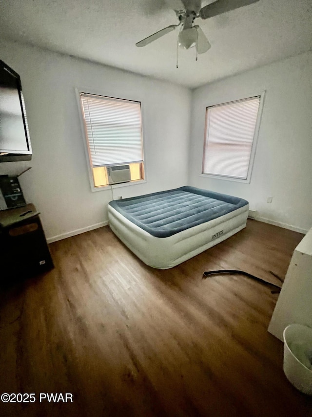 bedroom featuring ceiling fan, cooling unit, and dark hardwood / wood-style floors