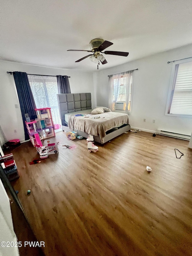 bedroom featuring ceiling fan, baseboard heating, and hardwood / wood-style floors