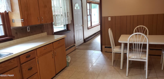 3307 Creamton Dr, Preston Park, PA 18455 - kitchen with a baseboard heating unit, light countertops, wood walls, brown cabinets, and wainscoting
