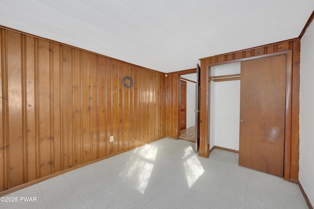 unfurnished bedroom featuring wood walls