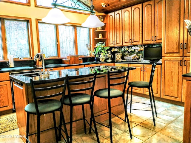 130 Willow Dr, Lords Valley, PA 18428 - kitchen featuring a sink, a breakfast bar, brown cabinets, and dark countertops