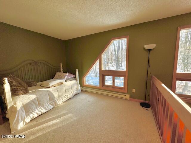 carpeted bedroom featuring a textured ceiling and a baseboard heating unit