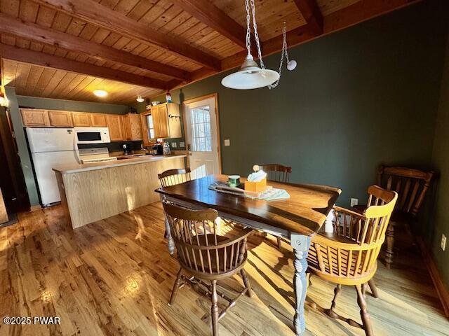 dining room featuring beam ceiling, wooden ceiling, and light hardwood / wood-style floors