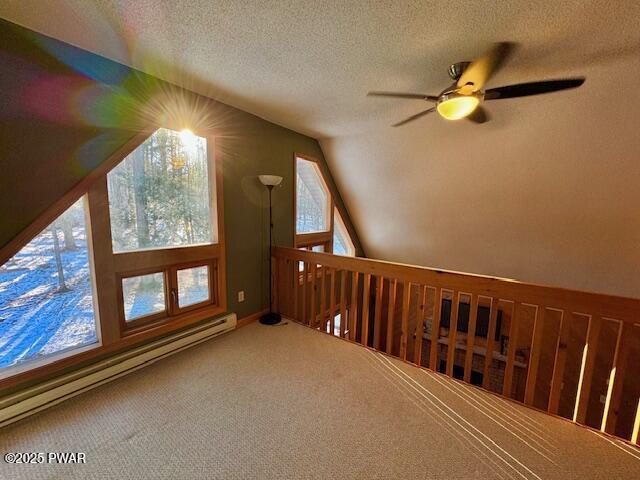 bonus room featuring lofted ceiling, ceiling fan, carpet flooring, a textured ceiling, and a baseboard radiator