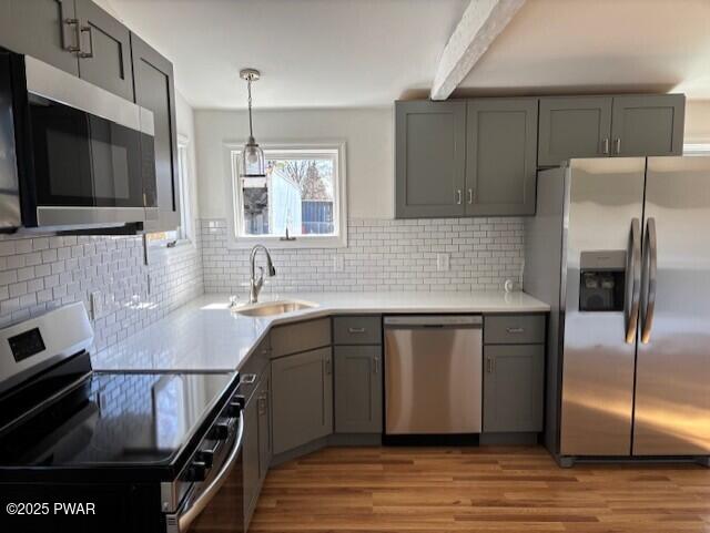 133 Arrowood Dr, Dingmans Ferry, PA 18328 - kitchen with tasteful backsplash, gray cabinets, light wood-style floors, stainless steel appliances, and a sink