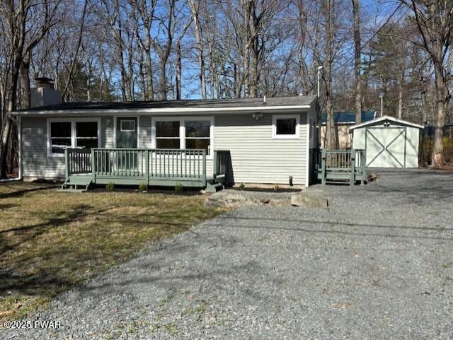 133 Arrowood Dr, Dingmans Ferry, PA 18328 - view of front of property featuring a detached garage, a chimney, an outdoor structure, a wooden deck, and driveway