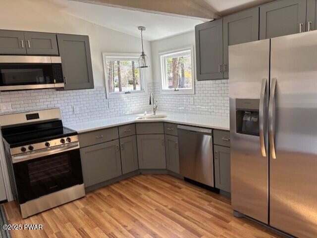 133 Arrowood Dr, Dingmans Ferry, PA 18328 - kitchen with gray cabinets, appliances with stainless steel finishes, a sink, light countertops, and lofted ceiling