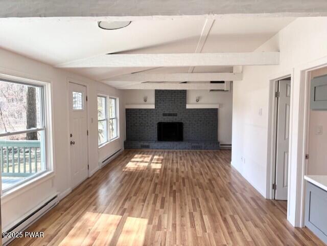 133 Arrowood Dr, Dingmans Ferry, PA 18328 - unfurnished living room featuring light wood-style floors, beamed ceiling, baseboard heating, an AC wall unit, and a baseboard radiator