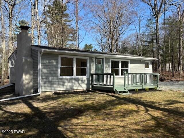 133 Arrowood Dr, Dingmans Ferry, PA 18328 - view of front of home with a front yard, a deck, and a chimney
