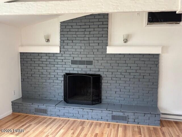 133 Arrowood Dr, Dingmans Ferry, PA 18328 - interior details with a fireplace, visible vents, a baseboard heating unit, and wood finished floors