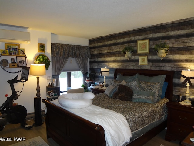 bedroom featuring a wall mounted AC, wooden walls, and hardwood / wood-style floors