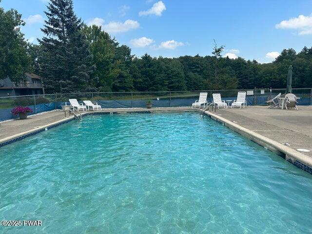 view of pool with a patio area and a water view