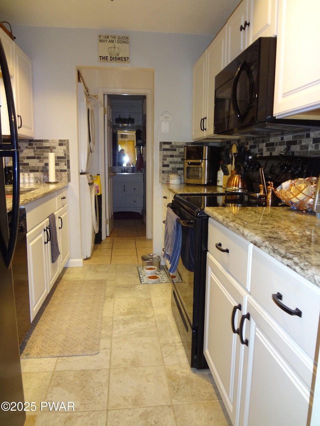 kitchen featuring black appliances, white cabinetry, backsplash, light stone counters, and light tile patterned floors