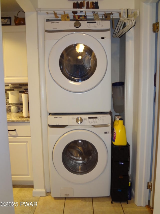 washroom featuring stacked washer and dryer and light tile patterned flooring