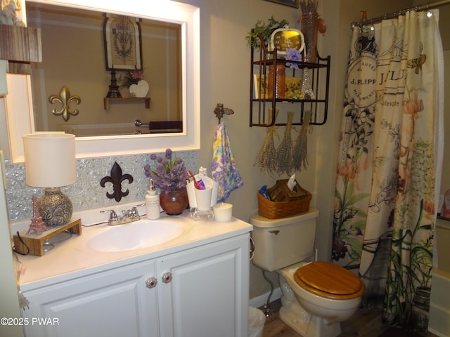 bathroom featuring toilet, vanity, and a shower with shower curtain