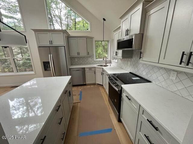 104 Maple Park Dr, Shohola, PA 18458 - kitchen with appliances with stainless steel finishes, vaulted ceiling, decorative backsplash, gray cabinets, and light countertops