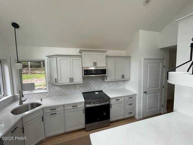 104 Maple Park Dr, Shohola, PA 18458 - kitchen featuring appliances with stainless steel finishes, vaulted ceiling, tasteful backsplash, light countertops, and dark wood-style floors