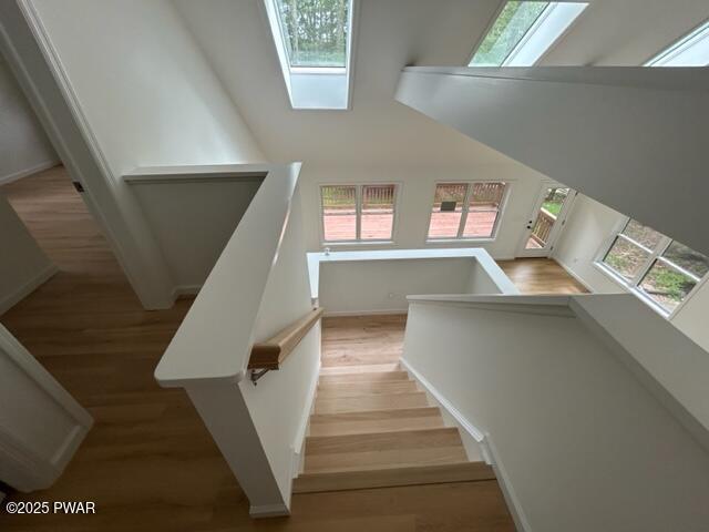 104 Maple Park Dr, Shohola, PA 18458 - stairs featuring a skylight, wood finished floors, and a high ceiling