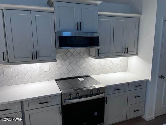 104 Maple Park Dr, Shohola, PA 18458 - kitchen featuring range with electric stovetop, stainless steel microwave, light countertops, and decorative backsplash