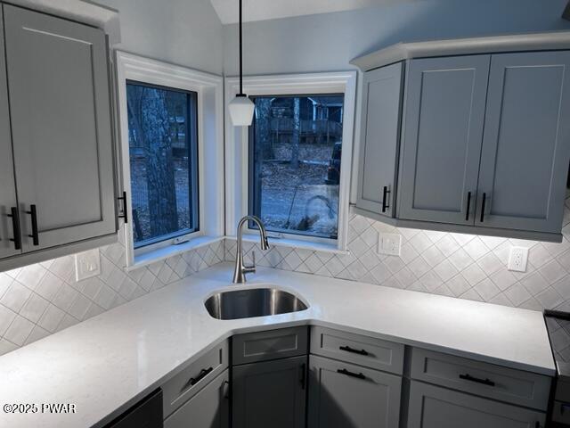104 Maple Park Dr, Shohola, PA 18458 - kitchen with decorative backsplash, gray cabinets, light countertops, and hanging light fixtures