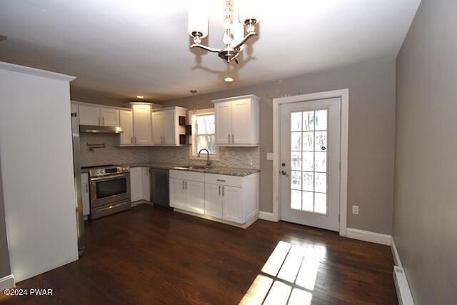 kitchen with a notable chandelier, white cabinets, sink, decorative light fixtures, and stainless steel appliances