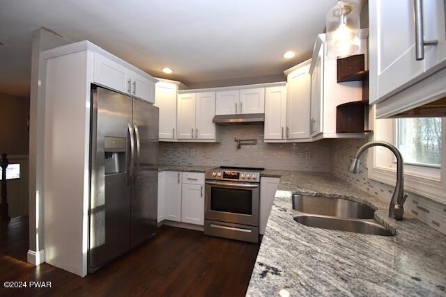 kitchen with white cabinets, sink, light stone counters, and stainless steel appliances