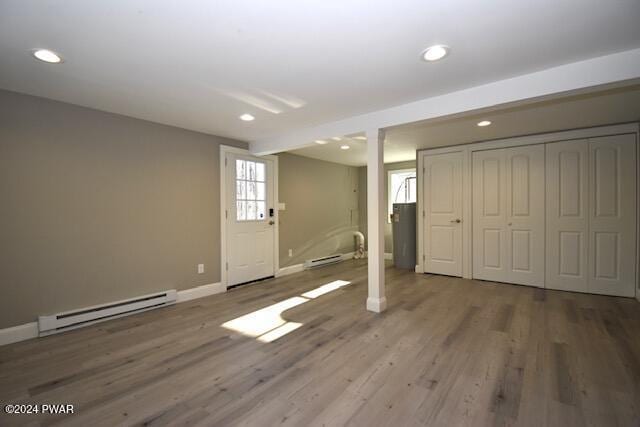 interior space featuring wood-type flooring and a baseboard heating unit