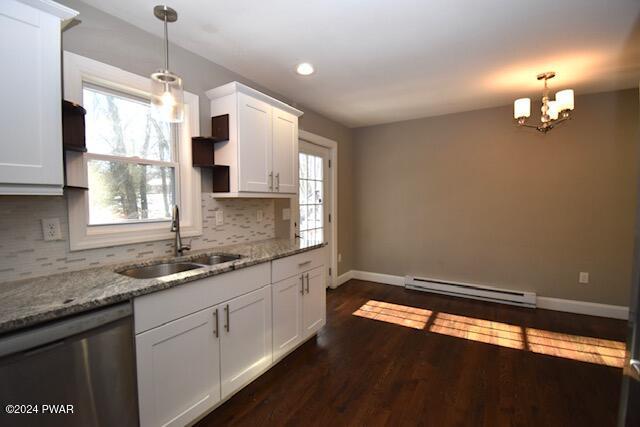 kitchen with sink, hanging light fixtures, stainless steel dishwasher, a baseboard heating unit, and white cabinets