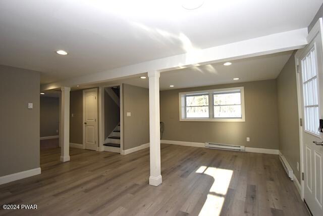 basement featuring hardwood / wood-style flooring and a baseboard heating unit