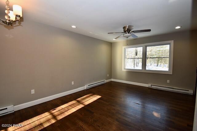 spare room with dark hardwood / wood-style flooring and a baseboard heating unit