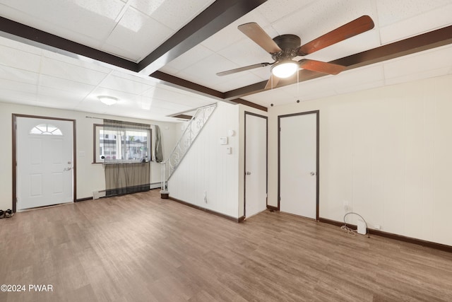 interior space featuring ceiling fan, a drop ceiling, a baseboard heating unit, and light hardwood / wood-style flooring