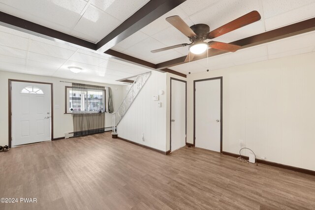 interior space featuring ceiling fan, a drop ceiling, a baseboard heating unit, and light hardwood / wood-style flooring