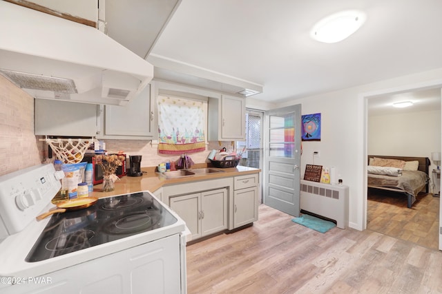 kitchen with radiator, ventilation hood, white electric range, sink, and light hardwood / wood-style floors