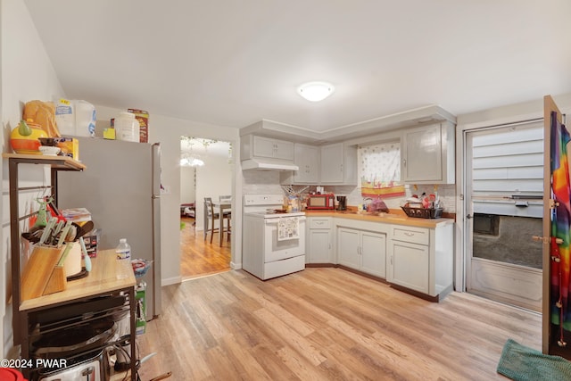 kitchen with sink, white electric stove, butcher block countertops, stainless steel fridge, and light wood-type flooring