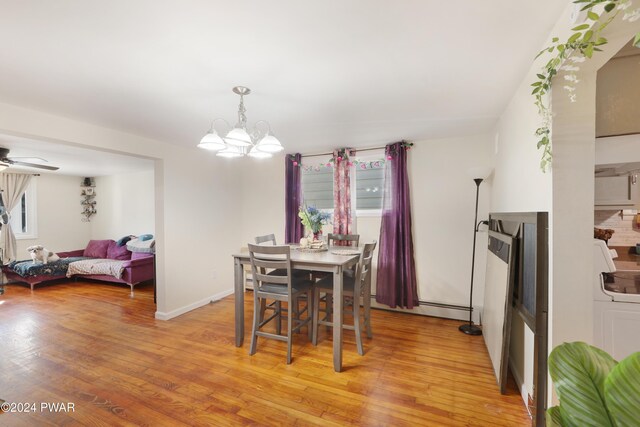 dining space with baseboard heating, ceiling fan with notable chandelier, and light wood-type flooring