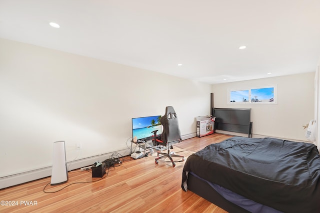 bedroom with wood-type flooring and a baseboard radiator